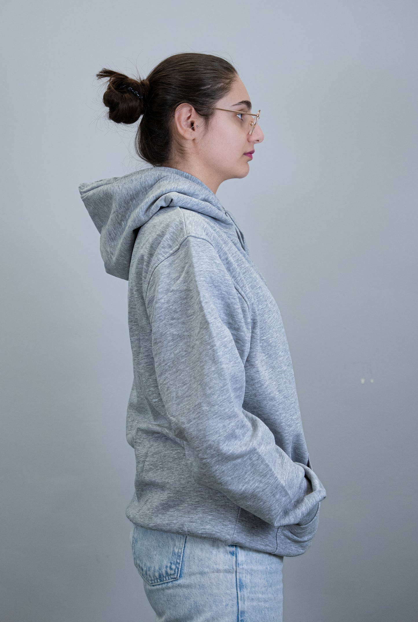 Side profile of a student wearing a grey IBU university hoodie, focusing on the back and side details