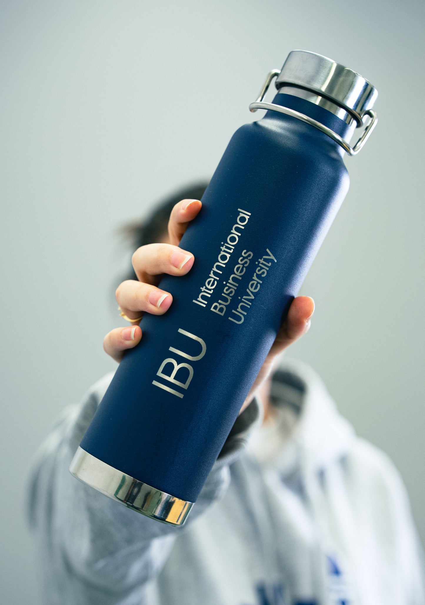 Student holding a Thermal Insulated Bottle from International Business University merch